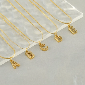 Detail of gold letter necklaces A to E with sparkling crystals on thin S-chains