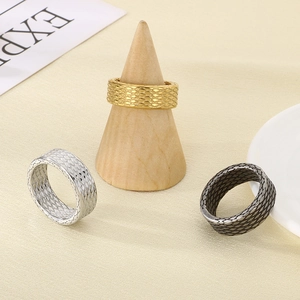 Macro shot of fish scale textured stainless steel rings in gold, silver and black colors