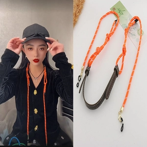 Orange braided eyewear chain detail showing adjustable rubber rings and leather neck pad