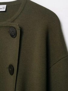 Detail of dark olive green knit cardigan featuring large black buttons and textured fabric