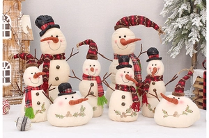 Detailed view of plush burlap snowman figurines with plaid hats and scarves in festive setting
