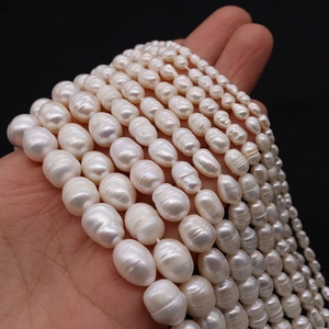 Natural white freshwater rice pearls held in hand for DIY necklace and bracelet jewelry