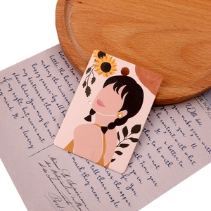 Close-up of pink and yellow jewelry display card featuring floral girl illustration