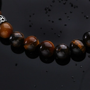 Men's vintage tiger eye beaded bracelet featuring a silver-colored Buddha head charm