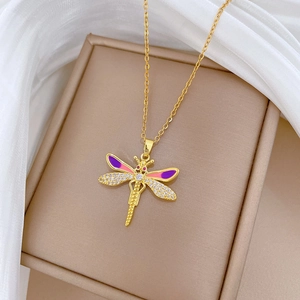 Gros plan détaillé d'un pendentif libellule doré avec émail violet et cristaux brillants