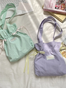 Minimalist canvas tote bags in pastel mint and purple colors with adjustable drawstrings