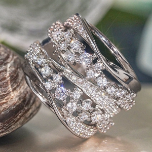 Macro shot of silver multi-layer crisscross ring with pavé and prong set crystals