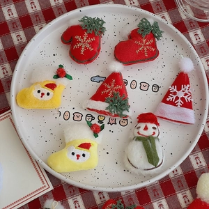 Detail of mini plush Christmas patches including snowman and festive socks on a tray