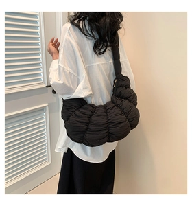 Detail of black pleated cloud bag with soft ruched texture and voluminous design