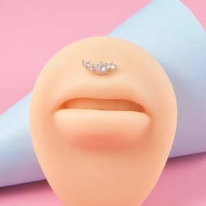 Vue macro d'un piercing labret en acier et zircons incurvés sur modèle en silicone