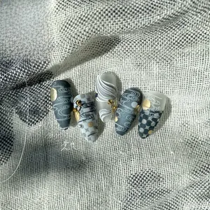 Macro shot of 3D wave embossing and gold foil accents on premium press-on nails