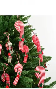 Detailed view of red and white fabric candy cane ornaments hanging on a Christmas tree