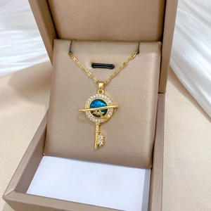Star and key necklace in gold with blue gem and crystals in a jewelry box