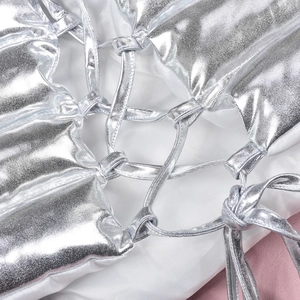 Detail of silver metallic skirt featuring quilted padding and cross-tie strap design