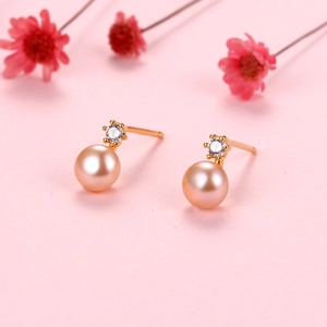 Macro shot of pink freshwater pearl earrings with gold six-claw zircon settings