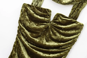 Detail of olive green velvet dress featuring ruched chest design and pleated fabric texture