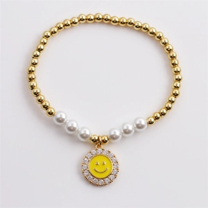 Beaded gold chain bracelet with white pearls and a yellow zircon smiley face charm