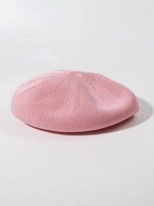 Detailed macro view of the soft pink knit texture and fine stitching on the beret
