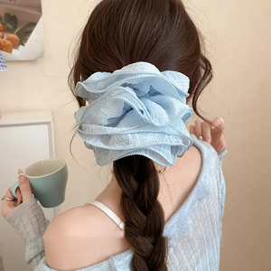 Grand chouchou en organza bleu clair sur une queue de cheval pour une coiffure élégante