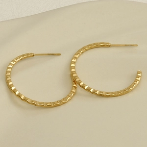 Detailed view of golden 304 stainless steel C-shaped earrings with hammered metal texture