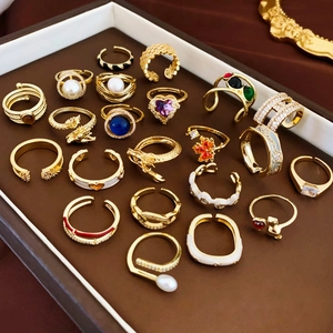 Collection of gold-plated rings with purple heart zircon, pearls, and colorful enamel charms