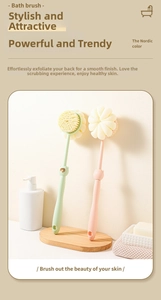 Detail of long-handled bath brush with soft bristles and mesh sponge on a wooden stand