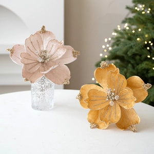 Faux magnolia Christmas flowers with pink velvet, gold glitter and beads in a vase