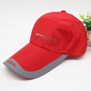 Detail of red quick-dry baseball cap with Modern British sports branding and long visor