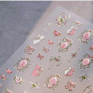 Détails macro d'autocollants pour ongles chat rose et or avec motifs nœuds en relief
