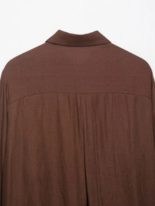 Macro shot of dark brown shirt back collar and textured shoulder fabric detail