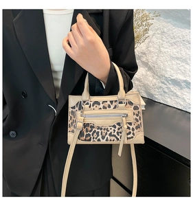 Detalle de bolso con estampado de leopardo y cremalleras de metal en cuero PU beige