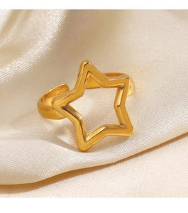 Detailed view of a gold pentagram star ring on soft beige silk fabric background