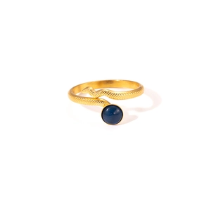 Detail of a golden snake-shaped titanium ring featuring a blue round gemstone inlay