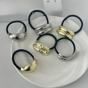 Close-up of geometric metal hair ties in gold and silver with various textures