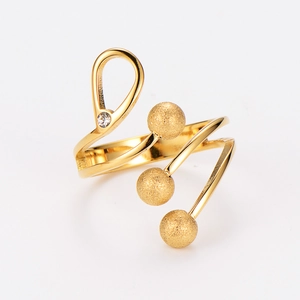 Detail of spiral gold-plated ring featuring frosted beads and a sparkling zircon inlay