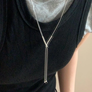 Long Y-shaped 925 sterling silver bead necklace worn over a black ribbed top