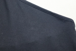 Detail shot of the tight black fabric weave and smooth stitching of the backless dress
