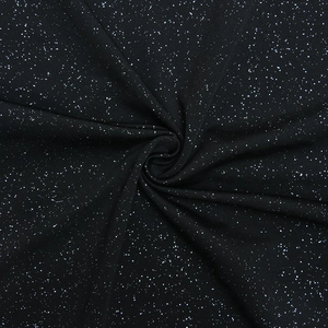 Macro detail of black fabric with sparkling white glitter dots and draped soft texture