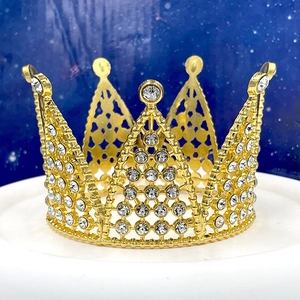 Dettaglio di corona dorata in metallo con strass scintillanti su sfondo blu stellato