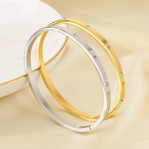 Close-up of 18k gold and silver plated bangles with sparkling crystals on satin