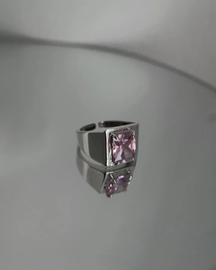Detail view of pink rectangular gemstone on a wide silver band with mirror reflection