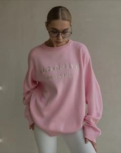Detail of soft pink oversized sweater with white ALSON CLUB embroidery on chest