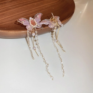 Detailed view of pink butterfly earrings with crystal tassels and pearl accents