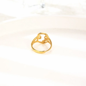 Macro shot of minimalist hollow abstract face ring in gold finish with sleek steel band