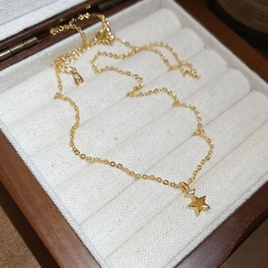 Dettaglio del ciondolo a stella dorata spazzolata con zircone su catenina fine
