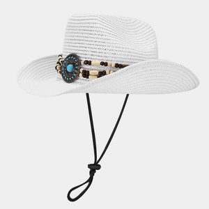 Detail of white straw cowboy hat with ethnic beadwork, turquoise inlay and chin strap
