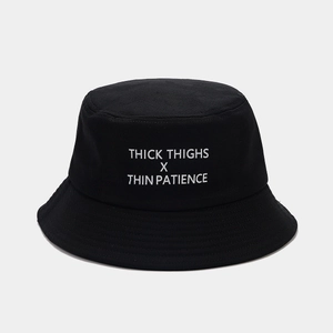 Détail du bob noir avec slogan blanc et coutures renforcées sur le bord du chapeau