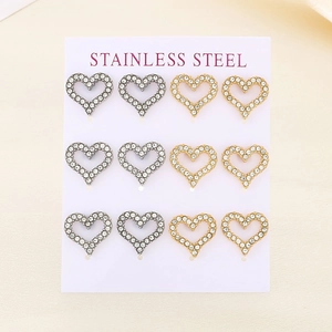 Macro detail of six pairs of heart-shaped stainless steel earrings in gold and silver