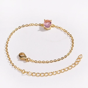 Gold plated bracelet featuring a pink oval gemstone with adjustable lobster clasp