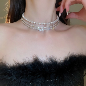 Close-up of elegant multilayer pearl choker with sparkling rhinestones on model neck